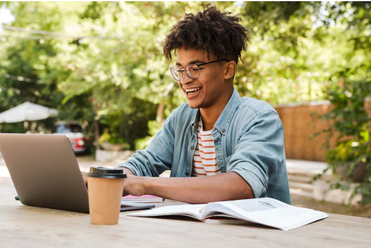 Jovem estudante feliz usando notebook