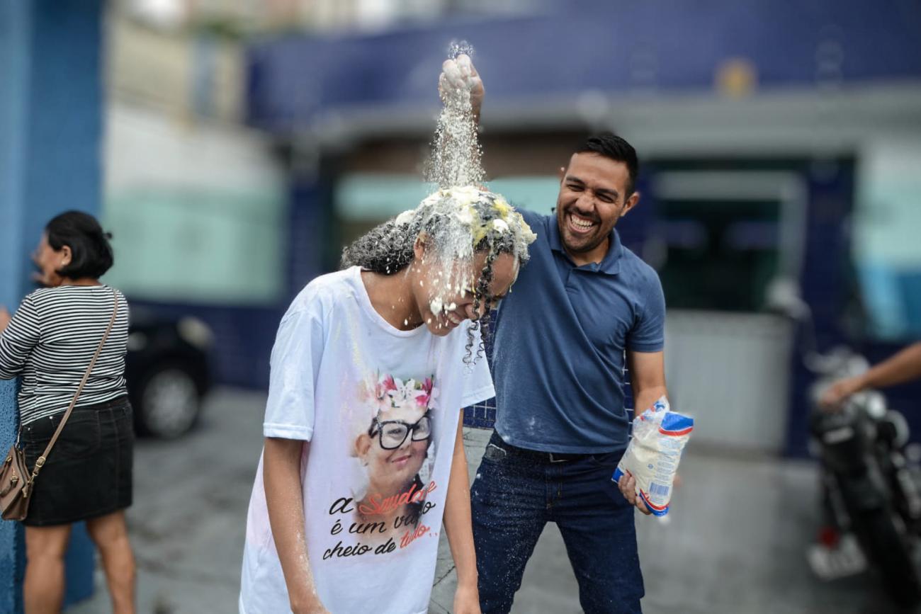 Iris Fernandes ganha o tradicional banho de trigo na comemora&ccedil;&atilde;o pela vaga em Licenciatura em Ci&ecirc;ncias da Religi&atilde;o (Foto: Rai Pontes / Ascom Seduc)